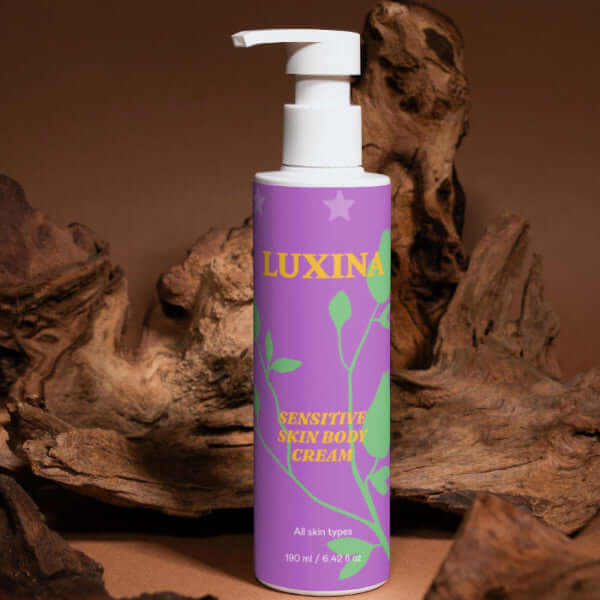 Purple bottle of Luxina Sensitive Skin Body Cream with wooden background