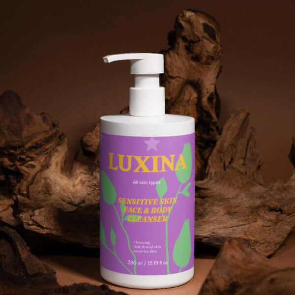 Luxina cleanser bottle with a purple label against a brown background